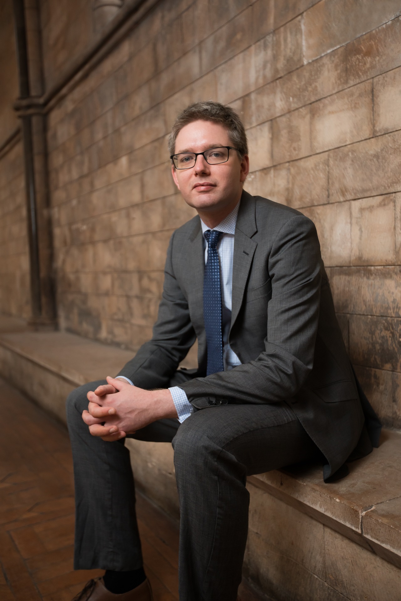 Man wearing a suit sat on stone steps